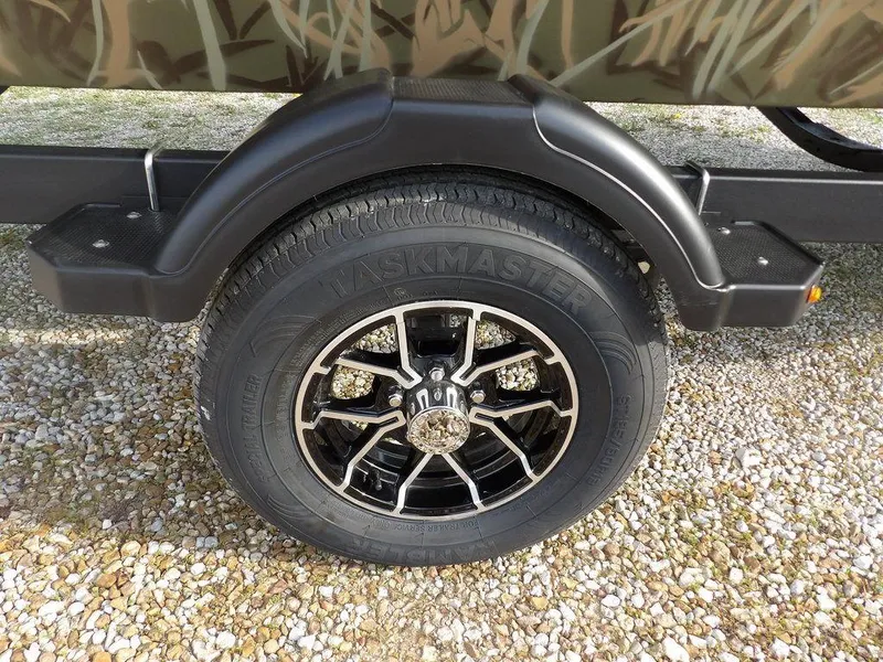 Slide: The Image of Trailer wheel of 2025 Crestliner 2070 Retriever SCHD with camo design and black alloy rim. - 37