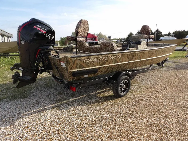 Slide: The Image of 2025 Crestliner 2070 Retriever SCHD boat with camo design on a trailer, parked outdoors. - 8
