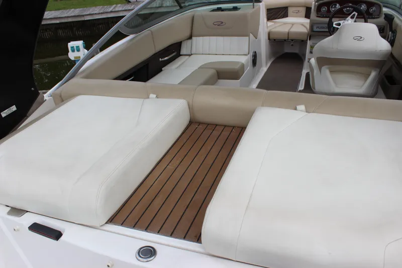 Slide: The Image of 2012 Regal 2100 RS Bowrider interior with beige seating and wooden deck. - 10