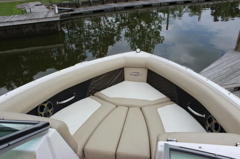Slide: The Image of 2012 Regal 2100 RS Bowrider boat with beige seating, docked by calm water. - 13