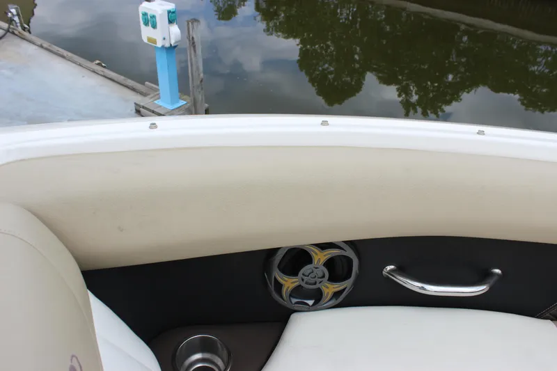 Slide: The Image of 2012 Regal 2100 RS Bowrider interior with speaker, cup holder, and water reflection. - 14