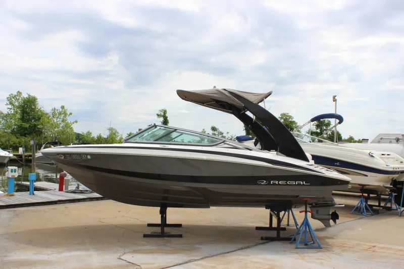 Slide: The Image of 2012 Regal 2100 RS Bowrider boat on stands, outdoor display. - 2