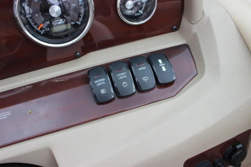 Slide: The Image of Dashboard controls of a 2012 Regal 2100 RS Bowrider boat, featuring switches and gauges. - 25