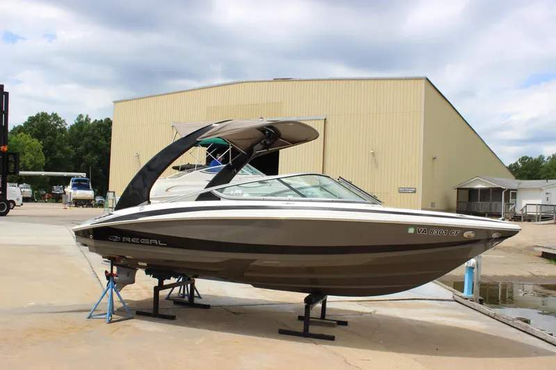 Slide: The Image of 2012 Regal 2100 RS Bowrider boat on stands near a warehouse. - 8