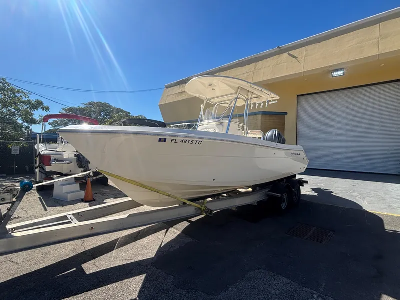 Slide: The Image of 2022 Cobia 237 Center Console boat on trailer, parked outside a building. - 1