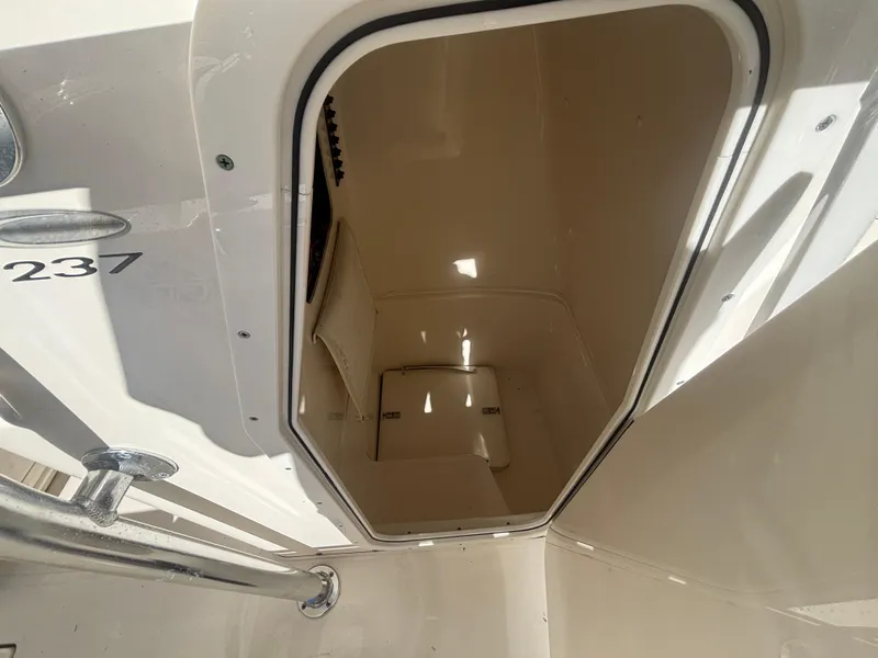 Slide: The Image of 2022 Cobia 237 Center Console storage compartment, open hatch, white interior. - 13