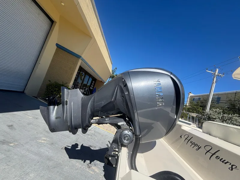 Slide: The Image of 2022 Cobia 237 Center Console boat with Yamaha outboard motor, parked near a building. - 4