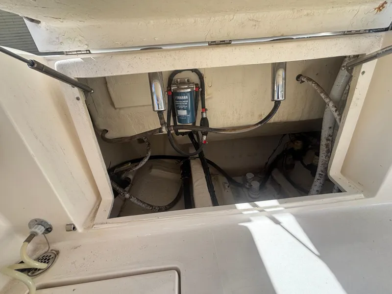 Slide: The Image of 2022 Cobia 237 Center Console boat's open storage compartment with visible wiring and components. - 8