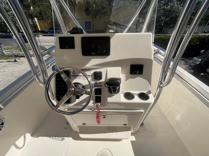 Slide: The Image of 2022 Cobia 237 Center Console boat dashboard with steering wheel and controls. - 9