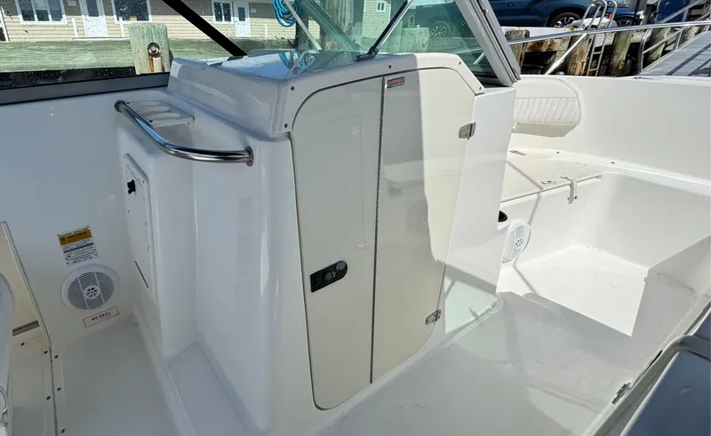 Slide: The Image of 2005 Boston Whaler 210 Ventura boat interior with white seating and storage compartments. - 10