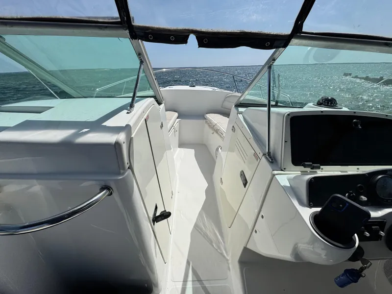 Slide: The Image of 2005 Boston Whaler 210 Ventura boat interior with ocean view, featuring helm and seating area. - 12