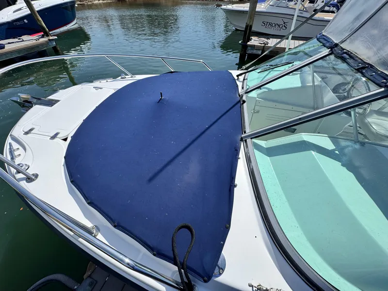 Slide: The Image of 2005 Boston Whaler 210 Ventura boat with blue cover docked at marina. - 17