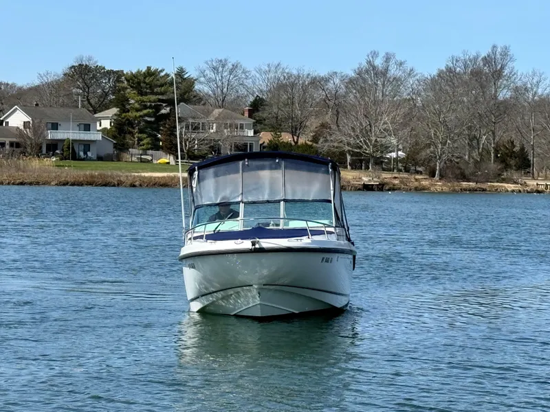 Slide: The Image of 2005 Boston Whaler 210 Ventura boat on calm water near residential shoreline. - 4