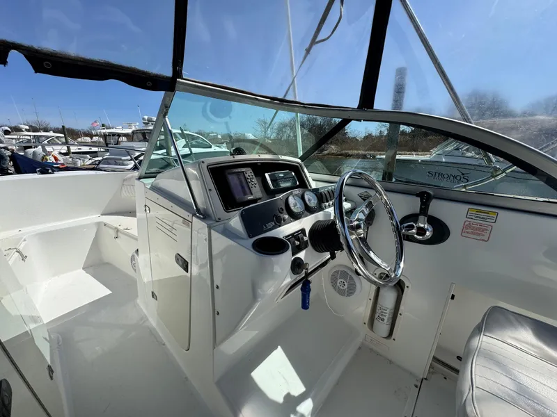 Slide: The Image of 2005 Boston Whaler 210 Ventura boat cockpit with steering wheel and control panel. - 5