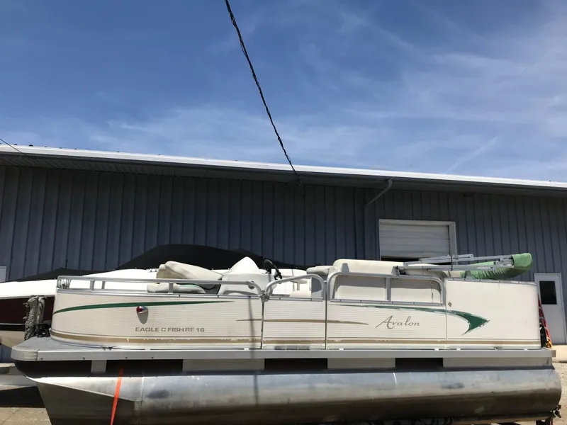 Slide: The Image of 2009 Avalon Eagle 16' pontoon boat parked outside a warehouse. - 1