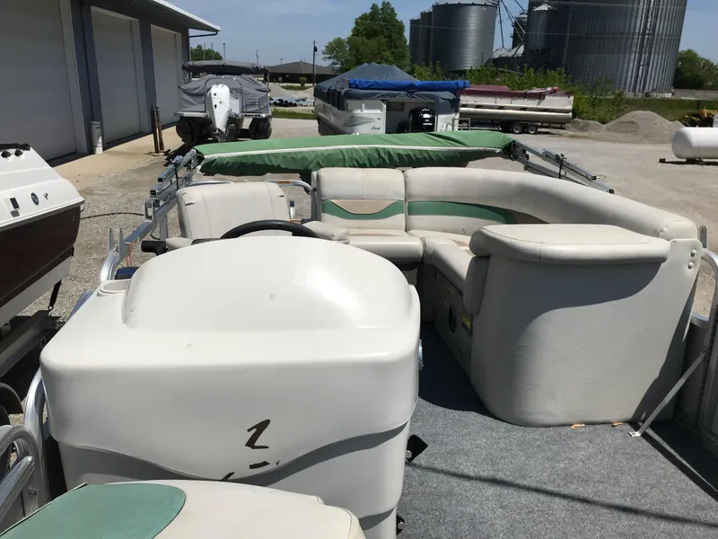 Slide: The Image of 2009 Avalon Eagle 16' pontoon boat with green and white seating, parked outdoors. - 10