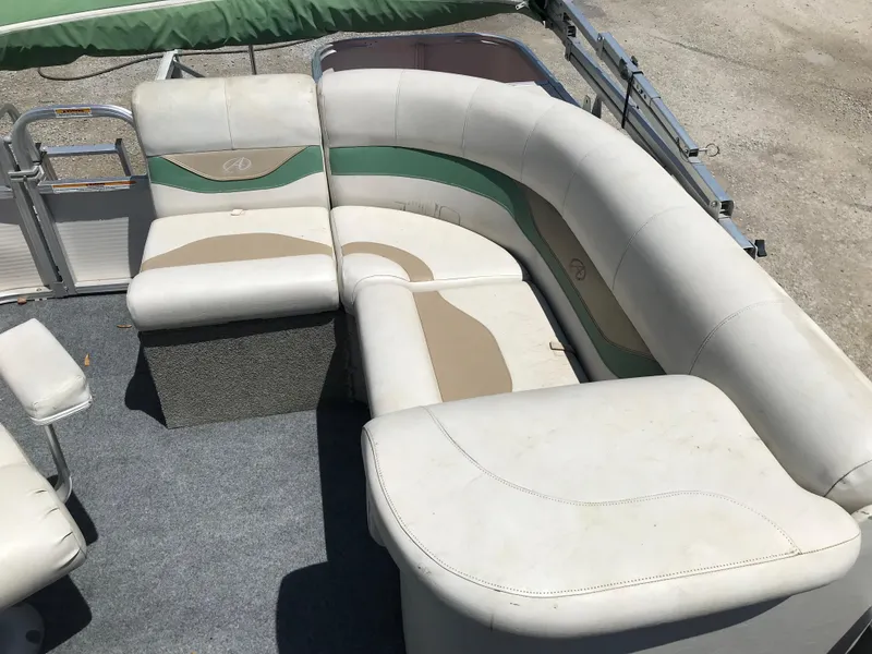 Slide: The Image of 2009 Avalon Eagle 16' boat interior with beige and green seating. - 13