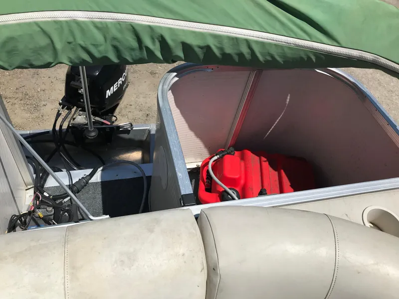 Slide: The Image of 2009 Avalon Eagle 16' boat with open storage, red fuel tank, and Mercury outboard motor. - 14