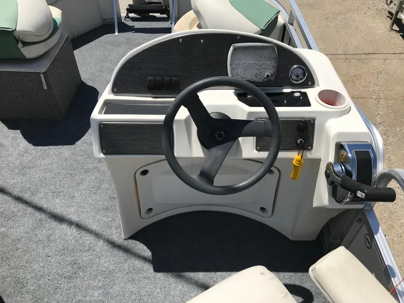Slide: The Image of Steering console of 2009 Avalon Eagle 16' boat with gray carpet and seating. - 15