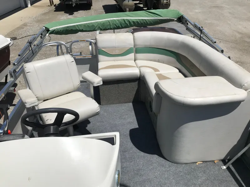 Slide: The Image of 2009 Avalon Eagle 16' boat interior with white seating and steering wheel. - 22