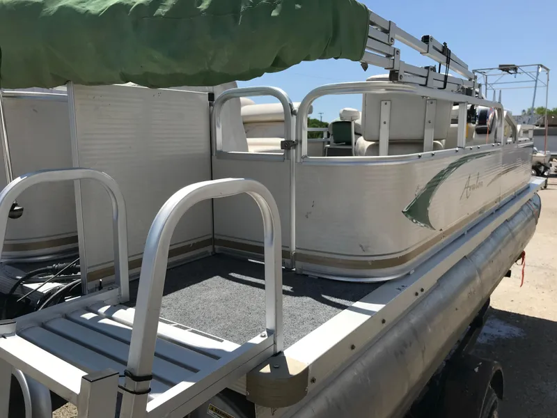 Slide: The Image of 2009 Avalon Eagle 16' pontoon boat with green canopy, docked outdoors. - 24
