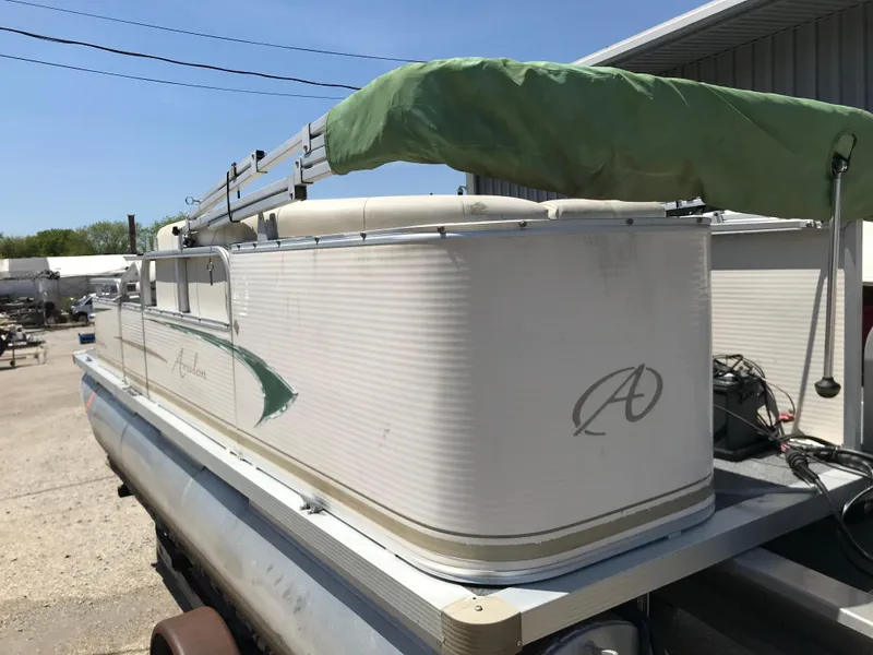 Slide: The Image of 2009 Avalon Eagle 16' pontoon boat with green canopy, parked outdoors. - 25