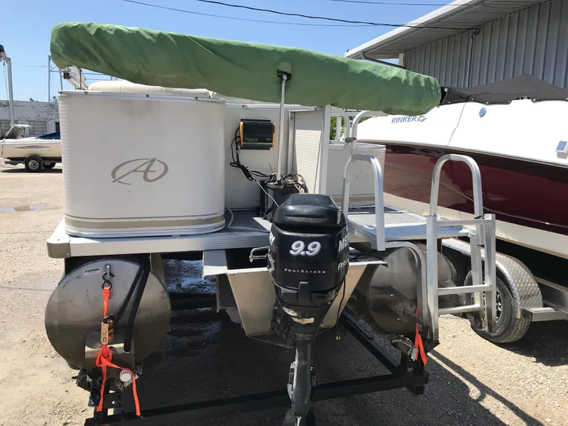 Slide: The Image of 2009 Avalon Eagle 16' pontoon boat with outboard motor and green canopy. - 4