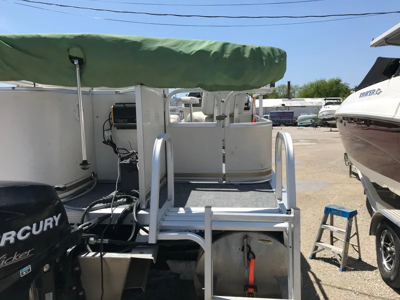 Slide: The Image of 2009 Avalon Eagle 16' boat with green canopy and Mercury motor in a marina. - 6