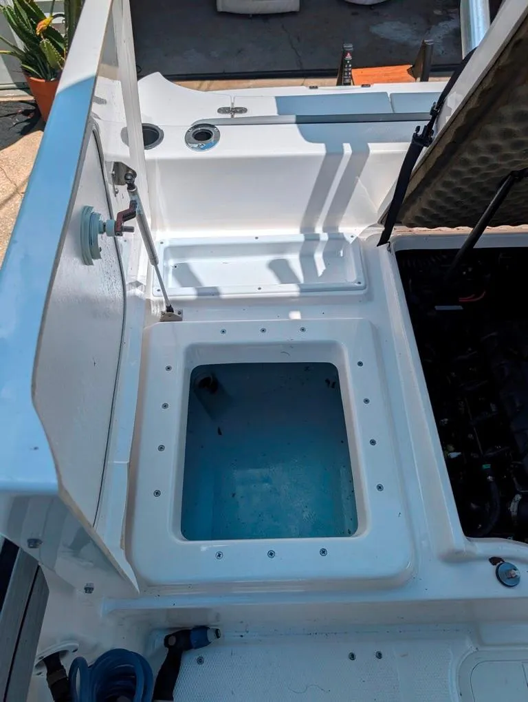 Slide: The Image of Open storage compartment on a 2021 Yamaha Boats 195 FSH Sport. - 10