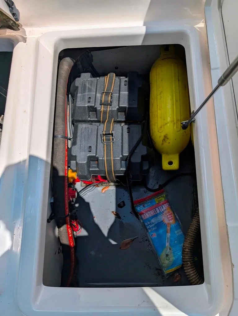 Slide: The Image of Storage compartment of a 2021 Yamaha Boats 195 FSH Sport with equipment and supplies. - 12