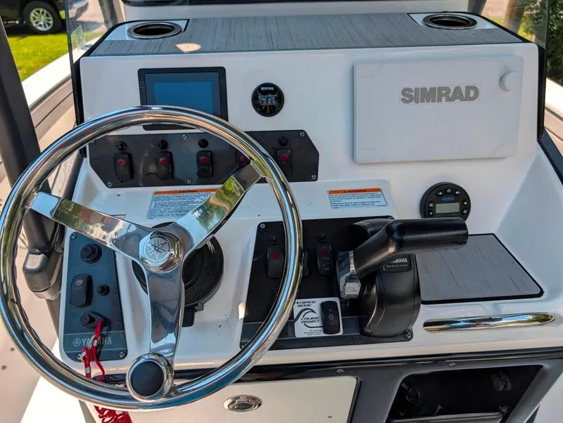 Slide: The Image of Control panel of 2021 Yamaha Boats 195 FSH Sport with steering wheel and Simrad display. - 14