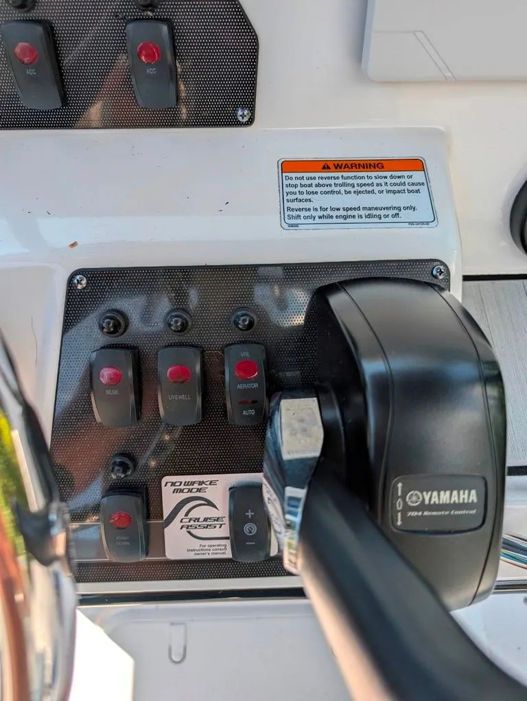 Slide: The Image of Control panel of 2021 Yamaha Boats 195 FSH Sport with switches and throttle lever. - 15