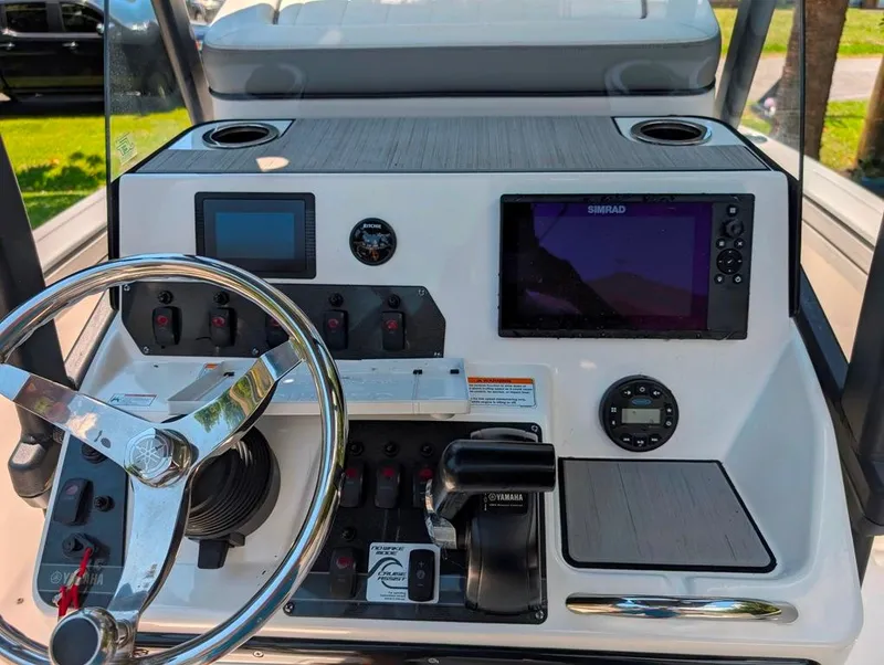 Slide: The Image of 2021 Yamaha Boats 195 FSH Sport dashboard with steering wheel and navigation controls. - 17