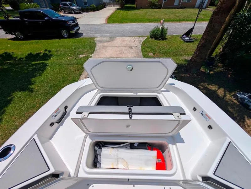 Slide: The Image of Open storage compartments on a 2021 Yamaha Boats 195 FSH Sport, parked in a driveway. - 19