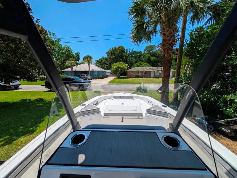 Slide: The Image of 2021 Yamaha Boats 195 FSH Sport in a residential driveway, surrounded by trees and houses. - 20