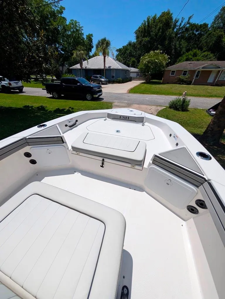 Slide: The Image of 2021 Yamaha Boats 195 FSH Sport interior, featuring spacious seating and storage compartments. - 21