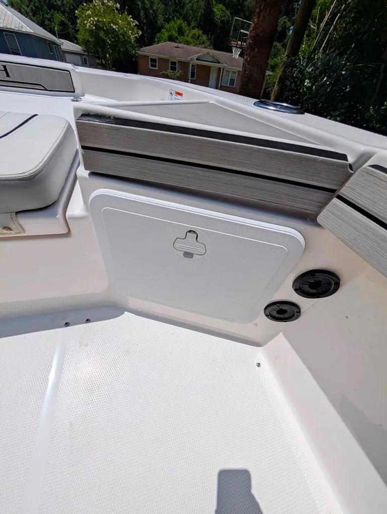 Slide: The Image of 2021 Yamaha Boats 195 FSH Sport interior detail with storage compartment and seating. - 22