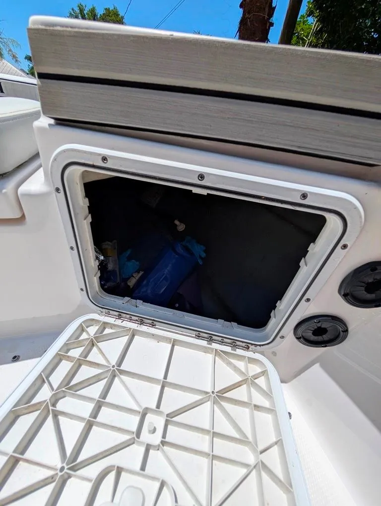 Slide: The Image of Open storage compartment on a 2021 Yamaha Boats 195 FSH Sport. - 23