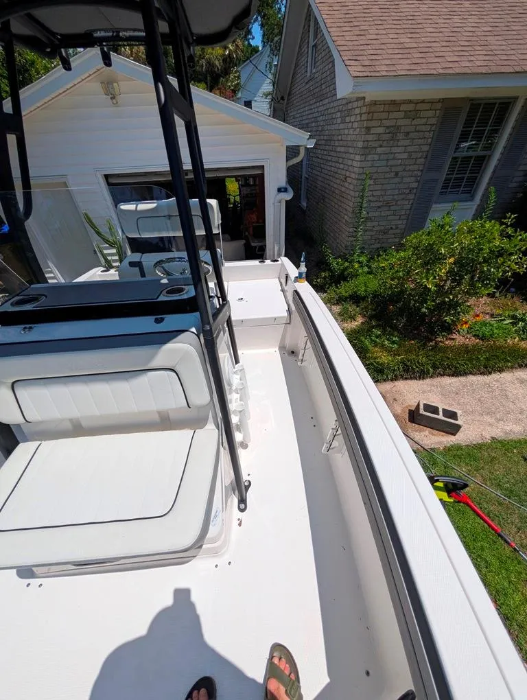 Slide: The Image of 2021 Yamaha Boats 195 FSH Sport in a residential driveway, showcasing interior seating and controls. - 25