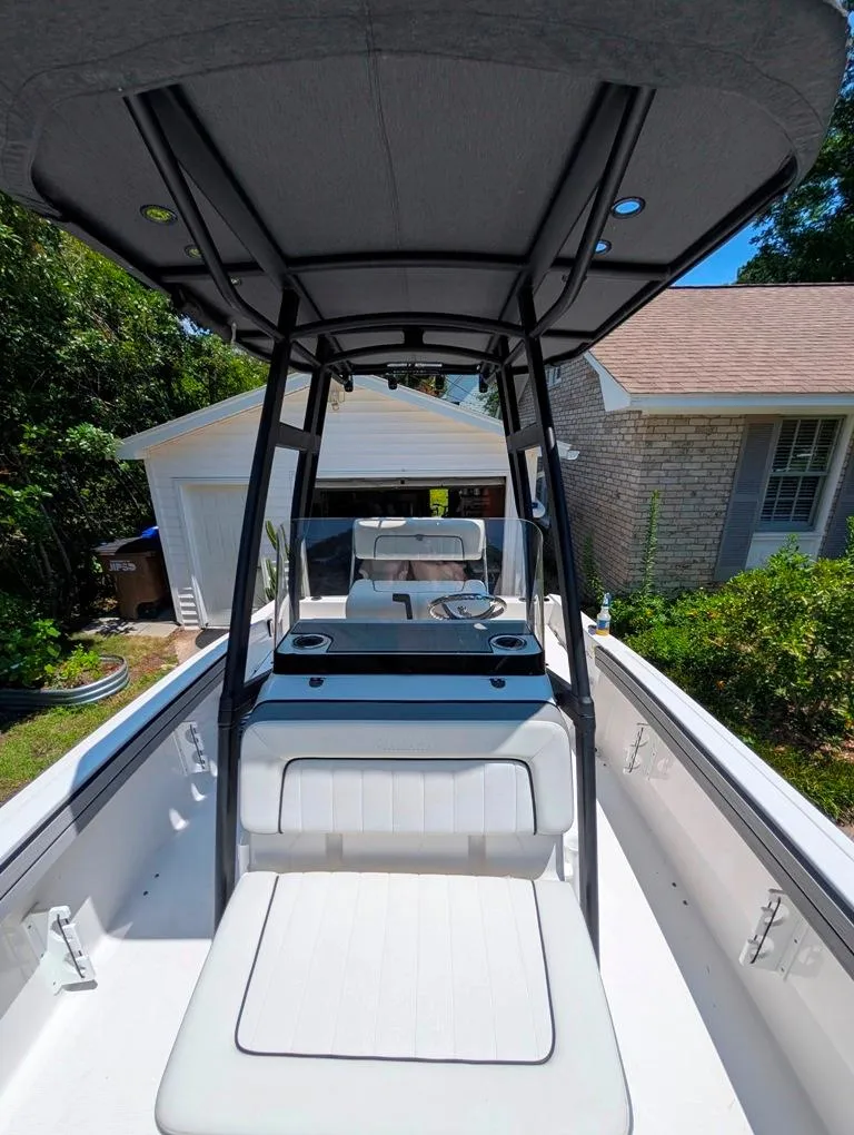 Slide: The Image of 2021 Yamaha Boats 195 FSH Sport in driveway, showcasing interior seating and console. - 26