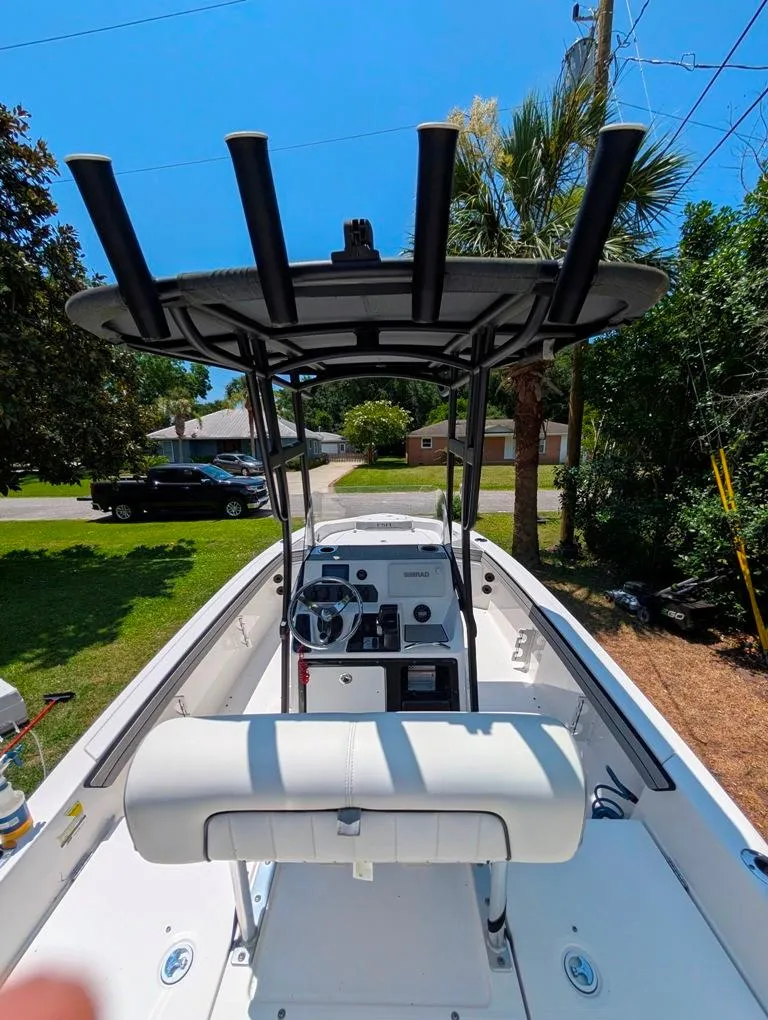 Slide: The Image of 2021 Yamaha Boats 195 FSH Sport, center console view, parked outdoors on a sunny day. - 29