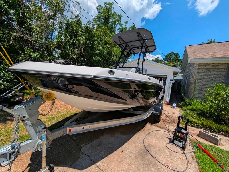 Slide: The Image of 2021 Yamaha Boats 195 FSH Sport on trailer, parked in driveway, surrounded by greenery. - 3