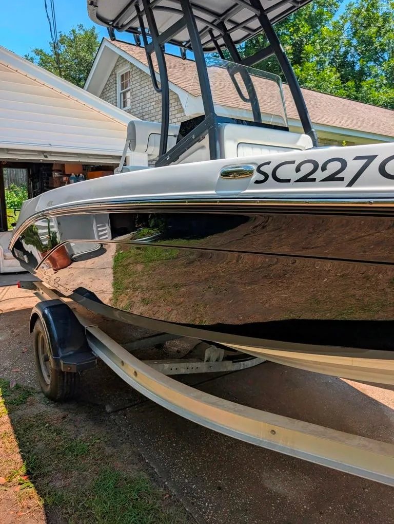 Slide: The Image of 2021 Yamaha Boats 195 FSH Sport on trailer, parked near a house. - 31