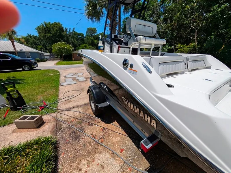Slide: The Image of 2021 Yamaha Boats 195 FSH Sport on trailer, parked in driveway, surrounded by greenery. - 32