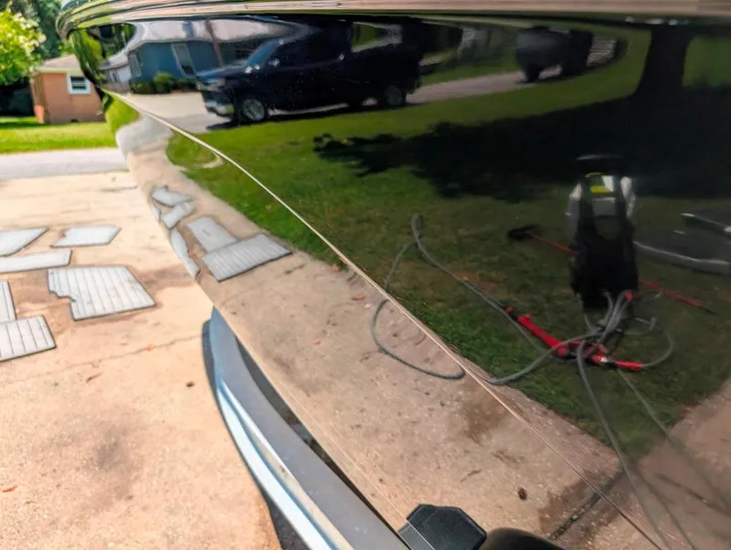 Slide: The Image of 2021 Yamaha Boats 195 FSH Sport with reflective hull, parked outdoors. - 39