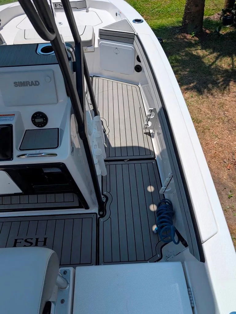 Slide: The Image of 2021 Yamaha Boats 195 FSH Sport interior with Simrad electronics and sleek deck design. - 44
