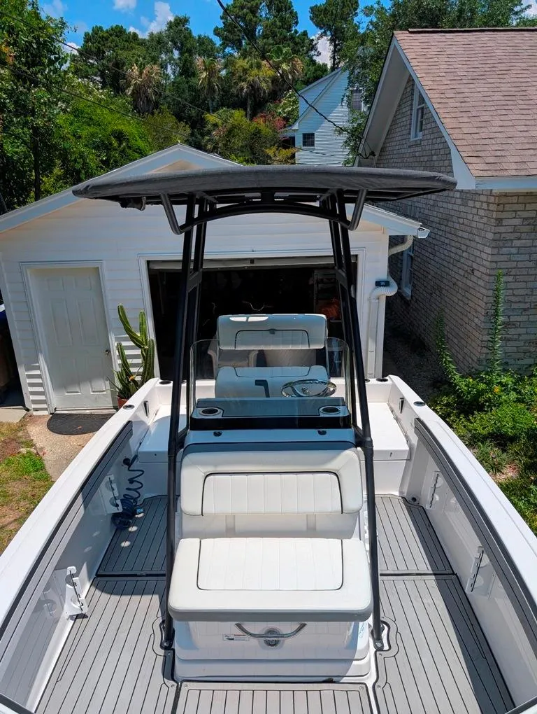 Slide: The Image of 2021 Yamaha Boats 195 FSH Sport in driveway, showcasing sleek design and seating. - 48