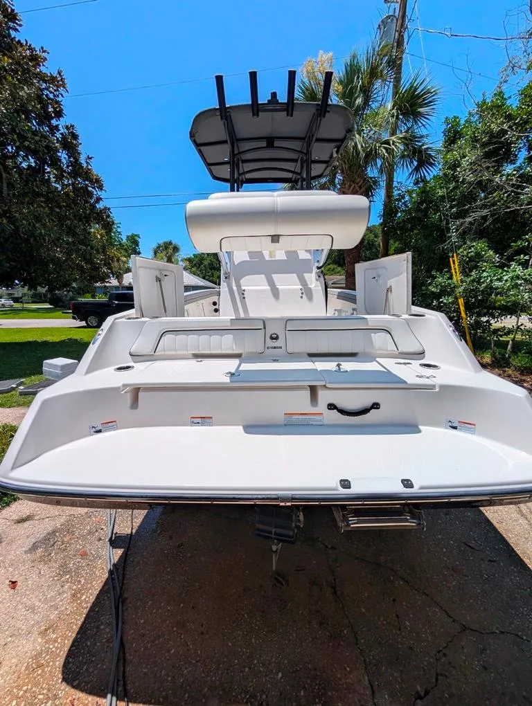 Slide: The Image of 2021 Yamaha Boats 195 FSH Sport, rear view, white deck, outdoor setting. - 7