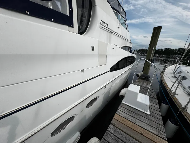 Slide: The Image of 2001 Carver 466 Motor Yacht docked at marina, side view with clear sky. - 10