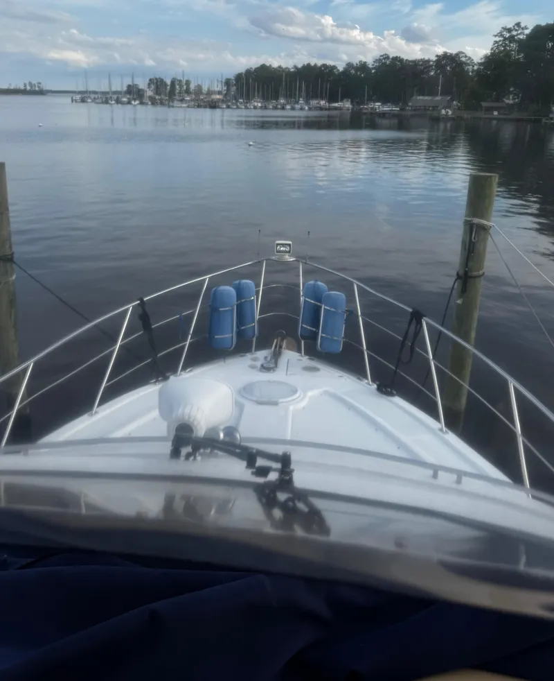 Slide: The Image of Bow view of 2001 Carver 466 Motor Yacht docked at a serene marina. - 12
